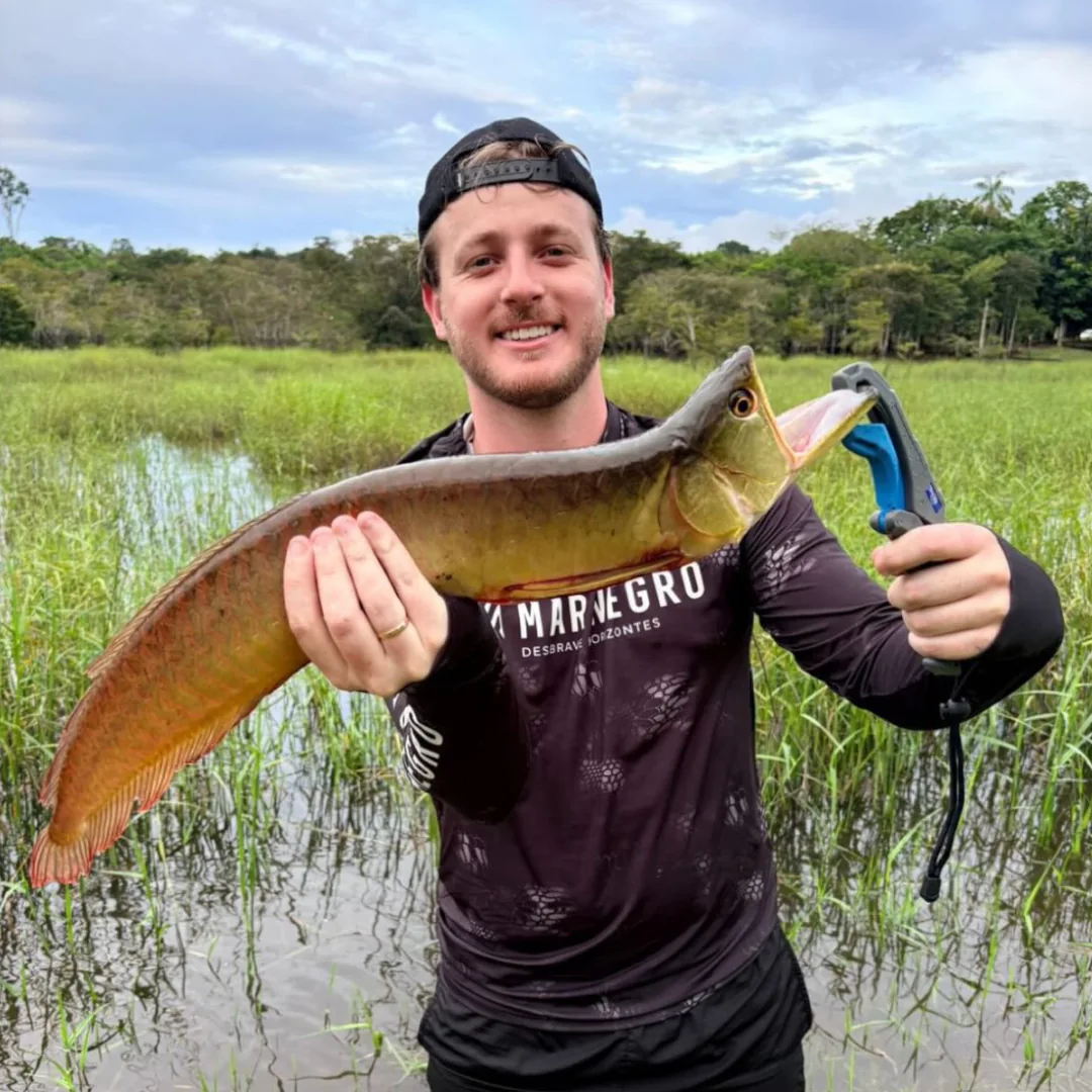 Pescador esportivo segurando uma grande cachorra mansa capturado na Represa de Balbina, Amazonas